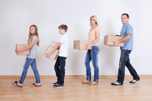Removal team carrying furniture from a shared house near Ealing